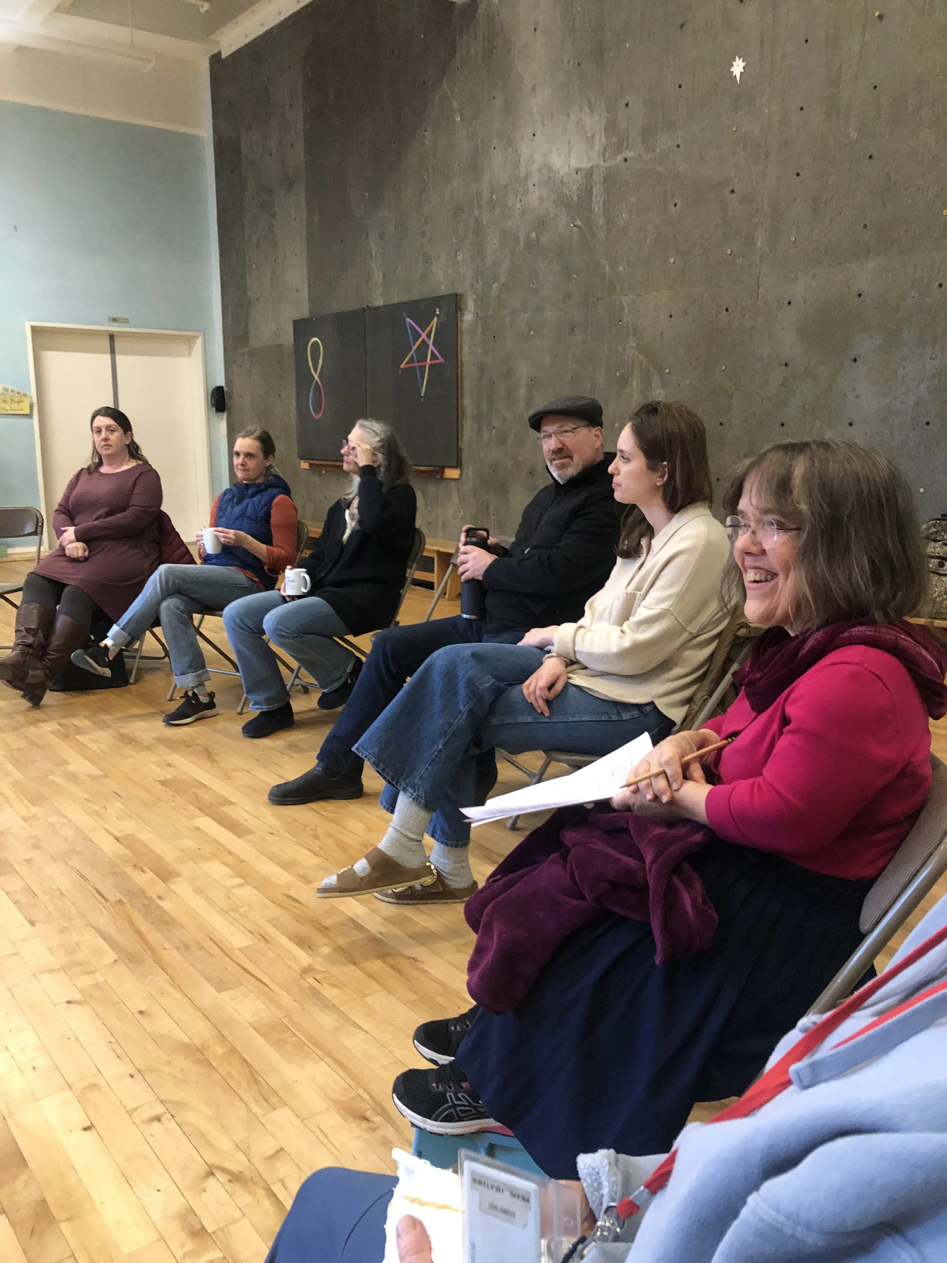 Meg speaking to a group of seated attendees in a community space