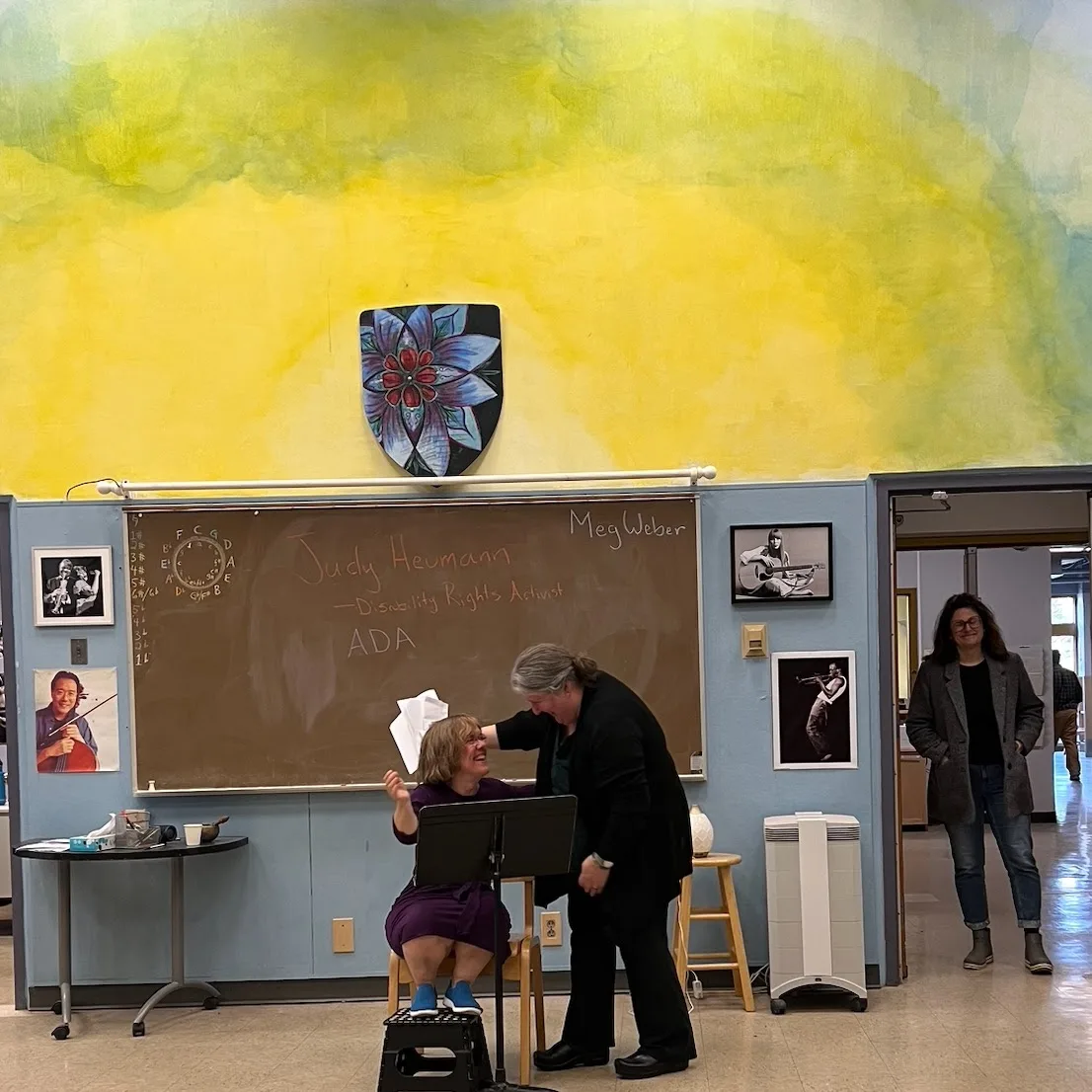 Meg laughing warmly with a colleague during a classroom visit