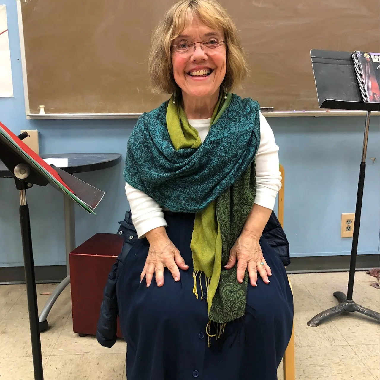 Portrait of Meg Weber smiling warmly, wearing a teal and green scarf